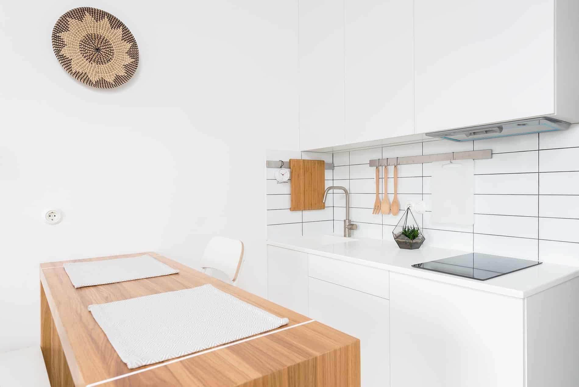 A white kitchen with a dining table